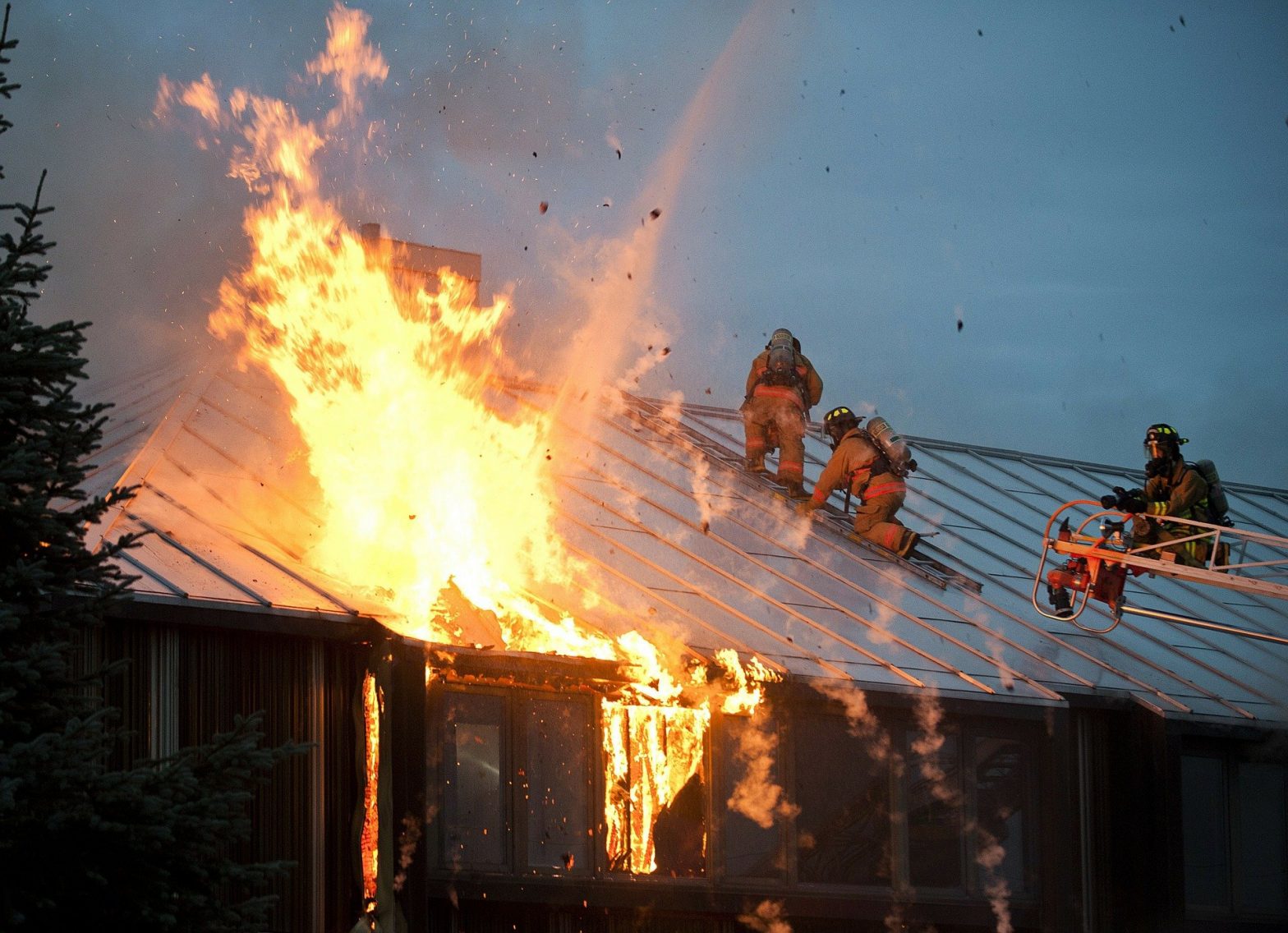 Foto de bombeiros apagando fogo em uma casa. Imagem ilustrativa para o texto incêndio e vandalismo.